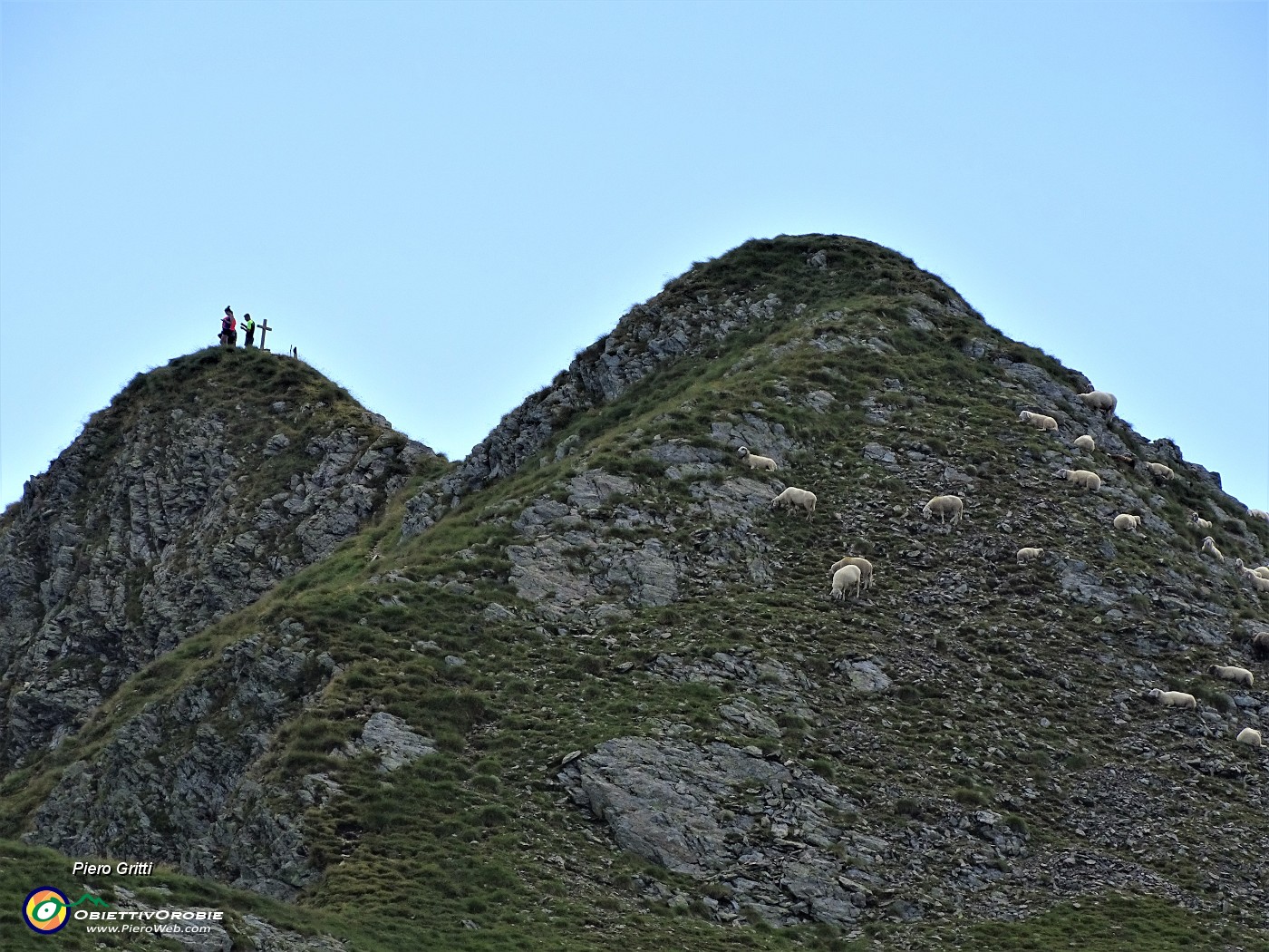 43 Zoom sul Monte Tribortoti (2300 m) con  escursionisti alla croce e pecore al pascolo.JPG
